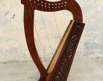 Lira escocesa de 12 cuerdas, color marrón, de palisandro, estilo celta. Incluye juego de cuerdas, llave de afinación y bolsa de transporte.