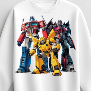 Könnte beinhalten: Weißes Sweatshirt mit einer farbenfrohen Grafik von drei Transformers-Charakteren: Optimus Prime in Rot und Blau, Bumblebee in Gelb und einem schwarz-roten Roboter. Das Design ist mittig auf dem Sweatshirt platziert.