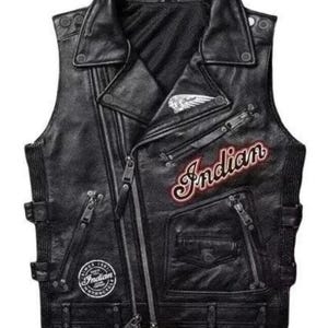 Könnte beinhalten: Eine schwarze Motorradweste aus Leder mit klassischem Design. Merkmale sind ein Reverskragen, mehrere Reißverschlusstaschen und das Wort "Indian" in roter Schrift mit weißer Kontur. Die Weste hat auch einen Aufnäher mit den Worten "Indian Motorcycle" und einem Logo.