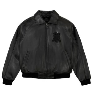 K&ouml;nnte beinhalten: Schwarze Leder-Bomberjacke mit Rei&szlig;verschluss, Kragen und schwarzem Emblem auf der Brust. Die Jacke hat zwei Vordertaschen und schwarze gerippte B&uuml;ndchen und Saum. Klassischer Stil.