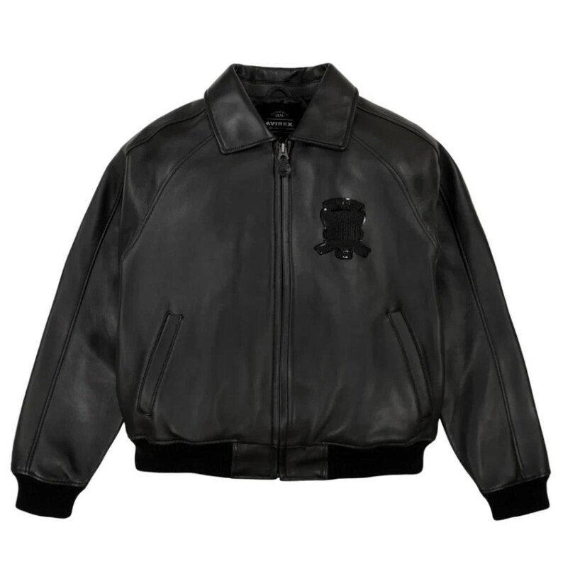 K&ouml;nnte beinhalten: Schwarze Leder-Bomberjacke mit Rei&szlig;verschluss, Kragen und schwarzem Emblem auf der Brust. Die Jacke hat zwei Vordertaschen und schwarze gerippte B&uuml;ndchen und Saum. Klassischer Stil.