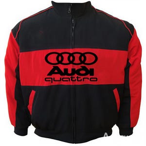 May include: Black and red zip-up jacket with the Audi Quattro logo. The jacket features a black body with red accents on the sleeves and a red horizontal stripe across the chest. The Audi logo is prominently displayed in black.