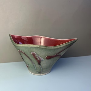 May include: A set of three ceramic mugs with a speckled, cream-colored glaze. Each mug features a different hand-painted floral design in shades of blue, green, and yellow. The mugs have a simple, rounded shape and a comfortable handle.