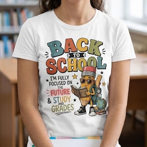 Può includere: Una t-shirt bianca con una grafica colorata che riporta il testo BACK TO SCHOOL, I'M FULLY FOCUSED ON THE FUTURE & STUDY AND GRADES. Il disegno raffigura un personaggio a forma di matita con occhiali da sole, che tiene un libro, un mappamondo e un righello.