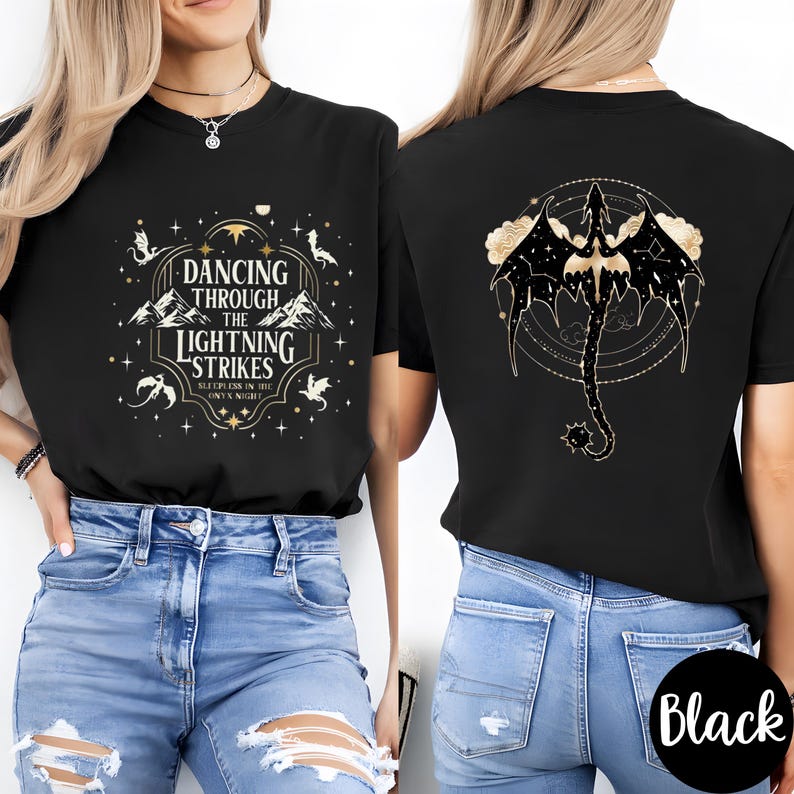 May include: Black t-shirt with a front graphic that reads "Dancing Through The Lightning Strikes" and a back graphic of a dragon with a circular design. The shirt is paired with blue jeans.