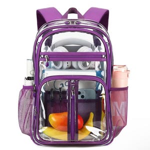May include: Clear backpack with purple trim, featuring multiple compartments and mesh side pockets. The backpack is filled with school supplies, including a water bottle, headphones, and fruit. The transparent design allows visibility of the contents.