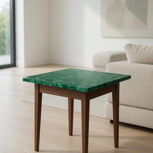 May include: A square side table with a green, marbled top and dark brown wooden legs. The table is approximately 24 inches tall and is set in a modern living room setting.
