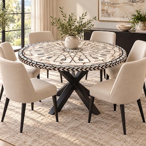 Puede incluir: Una mesa de comedor redonda con un patrón geométrico incrustado en blanco y marrón en la superficie, una base de metal negro en forma de X y seis sillas tapizadas en tela beige claro con patas de madera marrón oscuro alrededor.