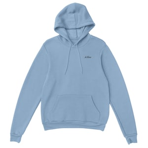 May include: A pale blue hoodie with a drawstring hood and a front kangaroo pocket. The hoodie features the embroidered text "In Bloom" in black on the upper chest.