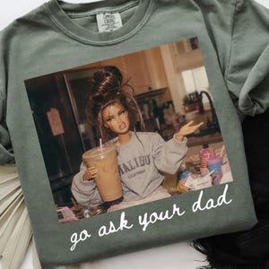 Op de afbeelding: Saliegroen Comfort Colors sweatshirt met een afbeelding van een pop die een ijskoffie vasthoudt. De pop draagt een grijs Malibu sweatshirt. De tekst "go ask your dad" staat eronder in witte letters.