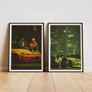 Puede incluir: Dos impresiones artísticas enmarcadas. Una muestra a dos personas sentadas en un coche amarillo y naranja, la otra a dos personas sentadas frente a un coche blanco. Ambas imágenes tienen un tinte verde y están ambientadas en un fondo de ciudad.