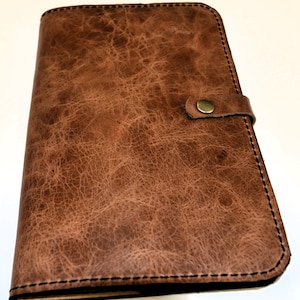 Funda de diario A5 de cuero hecha a mano. Incluye 2 ranuras para bolígrafos y 2 bolsillos para tarjetas de presentación. Se adapta a recambios A5 estándar.