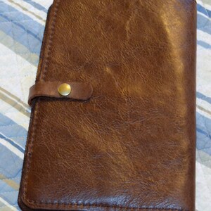 Funda de cuero para diario A5. Incluye 2 ranuras para bolígrafos. 2 bolsillos para tarjetas de presentación. Se adapta a recambios estándar A5.