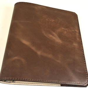 Caderno de couro marrom feito à mão com três argolas. Argolas de fichário de 1". Papel de caderno padrão com três furos. Dois bolsos internos.