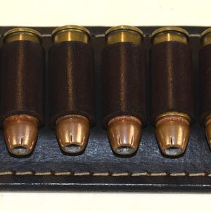 ハンドメイドのダークマホガニーレザーベルト弾薬キーパー。.44/45口径。6発の弾を収納可能。幅1 1/2インチまでのベルトにフィット。カートリッジは付属しません。