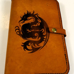 Capa para diário A5 feita à mão em couro de dragão gravado. Vem com 1 diário pautado A5 instalado. Dois suportes para caneta e dois bolsos para cartão.