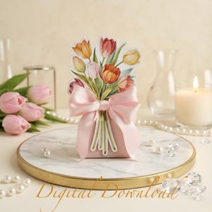 Puede incluir: Una caja de regalo rosa con una ilustración de un ramo de tulipanes, atada con un lazo de satén rosa. Los tulipanes son en tonos de rojo, naranja, amarillo y rosa. El texto "Digital Download" está en la parte inferior.