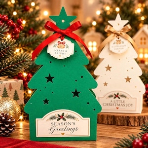 Könnte beinhalten: Eine grüne, baumförmige Geschenkbox mit Sternausschnitten, einer roten Schleife und einem Anhänger mit der Aufschrift Merry & Bright. Ein weißes Etikett an der Basis zeigt den Text Season's Greetings mit einer Stechpalmen-Illustration.