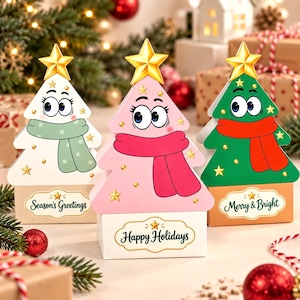 Peut inclure: Trois boîtes cadeaux triangulaires en forme de sapin de Noël, de couleurs blanche, rose et verte. Chacune possède une étoile dorée au sommet, un visage de dessin animé et une écharpe. Les boîtes portent les inscriptions Season's Greetings, Happy Holidays et Merry & Bright.