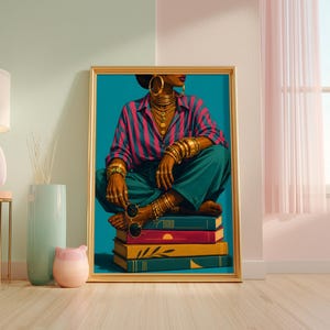 May include: A framed art print featuring a person wearing a pink and blue striped shirt and teal trousers, adorned with gold hoop earrings, layered necklaces, and multiple gold bracelets, sitting cross-legged on a stack of four colorful books.