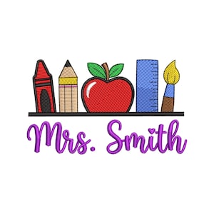 May include: An embroidered design featuring school supplies: a red crayon, a pencil, a red apple, a blue ruler, and a paintbrush. The name "Mrs. Smith" is written in purple script below the supplies, all on a white background.