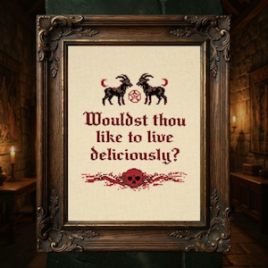 Könnte beinhalten: Kreuzstich-Kunstwerk in einem dekorativen Holzrahmen. Das Design zeigt zwei schwarze Ziegen, ein Pentagramm und den Text "Wouldst thou like to live deliciously?" in Burgunderrot. Ein Totenkopf- und Blumenmuster befinden sich am unteren Rand.