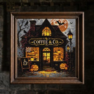 May include: Framed cross-stitch art depicting a Halloween-themed coffee shop. The shop, labeled "Coffee & Co.", is illuminated with warm light. Pumpkins, bats, and a full moon add to the spooky atmosphere. The artwork is set in a dark wooden frame.