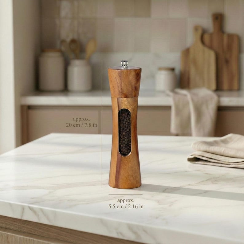 May include: A wooden pepper mill, approximately 7.8 inches tall, with a clear window displaying peppercorns. The mill has a natural wood finish and a silver-colored top. The base is approximately 2.16 inches wide. Kitchenware.