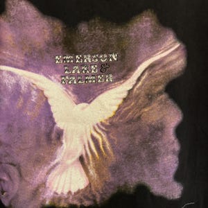 May include: Black t-shirt with a white dove graphic, wings spread, set against a purple and gold backdrop. The text "EMERSON LAKE & PALMER" is above the dove. A vintage design.