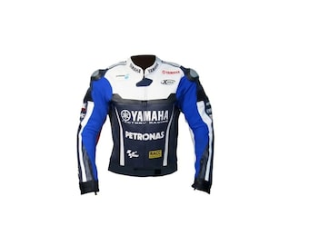 May include: A white, blue, and black Yamaha Factory Racing leather motorcycle jacket. The jacket features the Yamaha logo, Petronas branding, and other sponsor logos. It has a stand-up collar and padded shoulders.