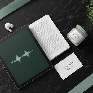 May include: A flat lay featuring a tablet with a sound wave graphic, a book, a small candle labeled "REfresh", a card with "I CHOOSE CALM", and white earbuds. The items are arranged on a black marble surface with green accents.