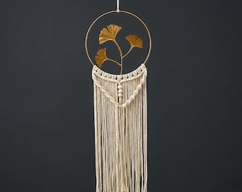 Decorazione da parete in macramè a forma di foglia di ginkgo, con cerchio dorato e frange in stile boho.