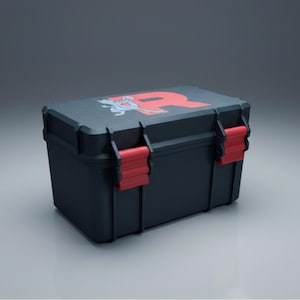 May include: A black storage case with red accents. The top of the case features a red letter "R" and a cartoon graphic. The case has red latches and hinges. The case is sitting on a reflective surface.