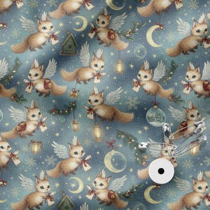 May include: A blue fabric featuring a repeating pattern of winged foxes, crescent moons, stars, snowflakes, and hanging lanterns. The foxes are light brown with white wings, and some hold scrolls. A silver safety pin is attached to the fabric.