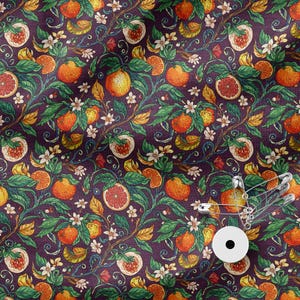 May include: A fabric featuring a repeating botanical pattern of orange fruits, sliced citrus, green leaves, and white blossoms set against a deep purple background, with a white circular tag and silver safety pins attached to the lower right corner.