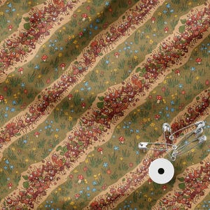 May include: A fabric featuring a repeating pattern of diagonal stripes filled with illustrated red ants marching through green grass, small blue flowers, and red mushrooms. Three silver metal safety pins are attached to the fabric.