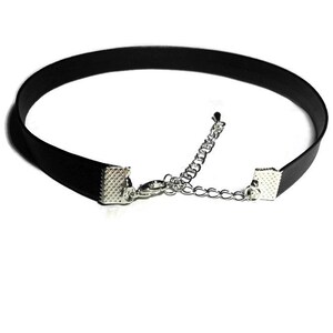 May include: A black velvet choker with silver metal clasps and a chain extender.