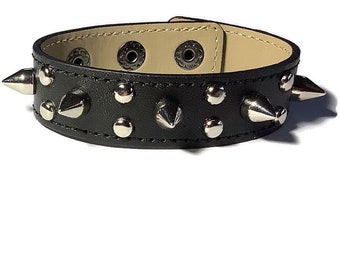 May include: Black leather bracelet with silver studs and spikes.