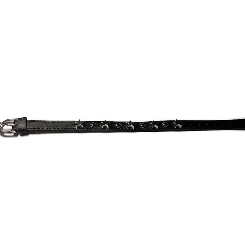 May include: A black leather bracelet with silver star-shaped studs.