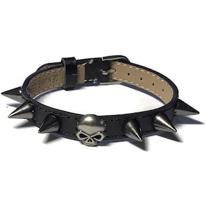May include: Black leather bracelet with silver spikes and a skull charm. The bracelet has the text "GENUINE LEATHER" on the back.