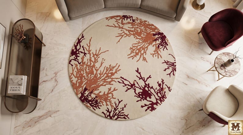 Puede incluir: Una alfombra circular con un fondo de color crema y un patr&oacute;n repetitivo de ramas similares al coral en tonos burdeos intenso, rojo oscuro y naranja apagado. El dise&ntilde;o se extiende por toda la superficie de la alfombra redonda.