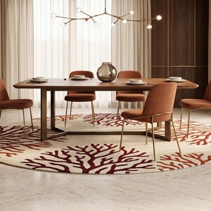 Puede incluir: Una mesa de comedor rectangular de madera con base de metal oscuro, rodeada de seis sillas tapizadas en tela naranja quemado con patas finas de tono dorado, sobre una gran alfombra circular con un patr&oacute;n de coral rojo sobre fondo crema.