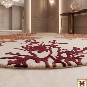 Puede incluir: Una alfombra circular con una base de color crema y patrones texturizados en relieve en tonos burdeos profundo y naranja quemado que se asemejan a corales org&aacute;nicos o estructuras ramificadas. La alfombra tiene un pelo grueso y tupido.