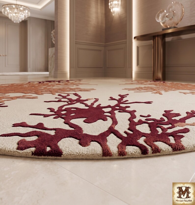 Puede incluir: Una alfombra circular con una base de color crema y patrones texturizados en relieve en tonos burdeos profundo y naranja quemado que se asemejan a corales org&aacute;nicos o estructuras ramificadas. La alfombra tiene un pelo grueso y tupido.