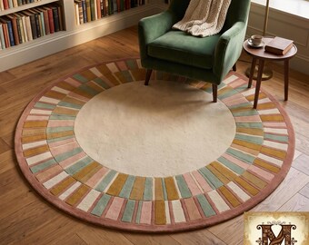 May include: A round area rug featuring a large cream-coloured centre circle surrounded by a wide border of alternating rectangular segments in muted shades of dusty pink, sage green, and mustard yellow, finished with a solid terracotta-coloured edge.