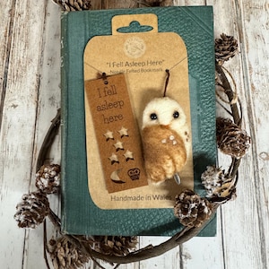 May include: A handmade needle felted bookmark with an owl design. The bookmark is brown with a white owl and the text "I fell asleep here". The bookmark is attached to a green book.