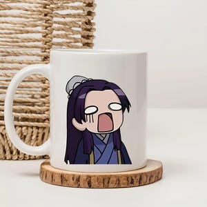 Könnte beinhalten: Weiße Keramiktasse mit einem Cartoon-Charakter mit langen lila Haaren, großen Augen und offenem Mund, gekleidet in einem blau-violetten Outfit. Die Tasse steht auf einem Holzuntersetzer und hat einen gebogenen Henkel.