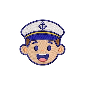 May include: Embroidered sailor face with a white hat featuring a blue anchor, blue trim, and a yellow band. The face has a smiling expression with a pink tongue, brown hair, and tan skin. This design is suitable for nautical-themed crafts.