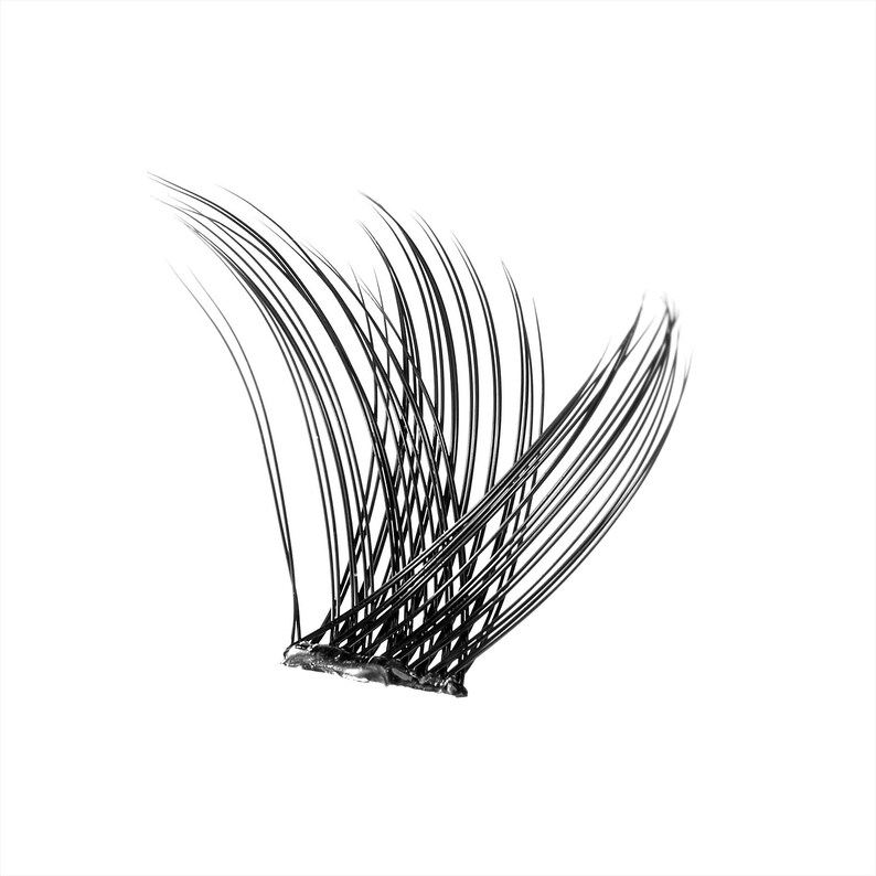 Op de afbeelding: Een cluster van zwarte valse wimpers, in een gebogen vorm. De individuele wimpers zijn lang en slank, bevestigd aan een dunne, donkere basis. De achtergrond is effen wit.