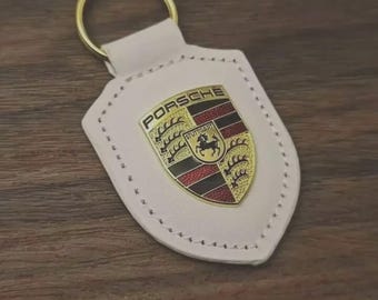 Llavero con el escudo de Porsche, de cuero y plateado, en una exquisita caja de regalo.